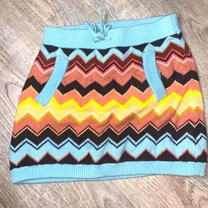 It has pockets and has a tie in the middle. It is also muti colored.